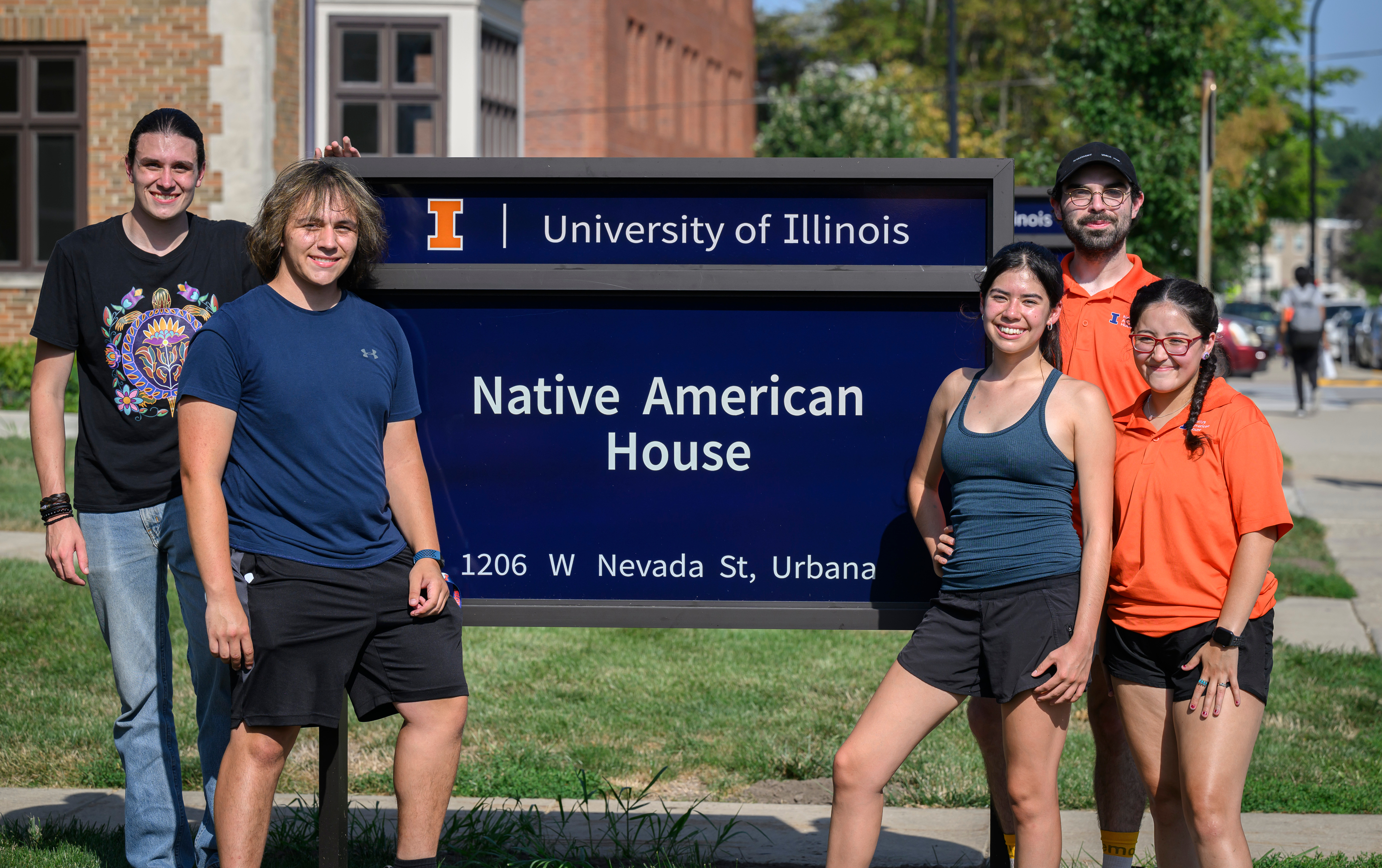 students standing in front of an outdoor sign outside 